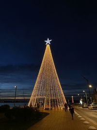 Illuminated christmas tree against sky at night