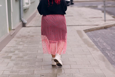 Low section of woman walking on footpath