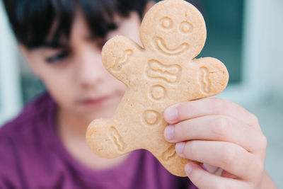Close-up portrait of boy holding cookies