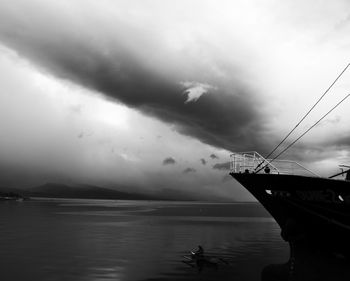 Boats in sea against cloudy sky