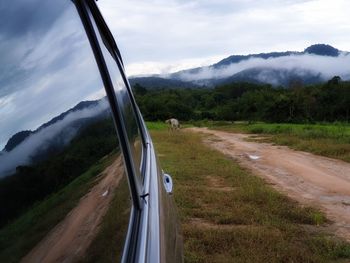 Car on road by land against sky