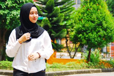 Young woman wearing scarf while standing outdoors