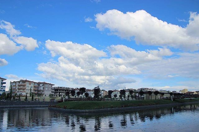 architecture, building exterior, built structure, sky, water, cloud - sky, river, waterfront, cloud, city, cityscape, residential building, residential structure, tree, residential district, house, blue, day, town, lake