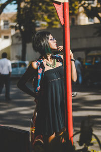 Woman with umbrella standing in city