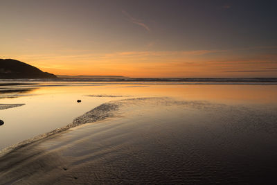 Scenic view of beach against sky during sunset