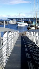 Boats moored at harbor against sky