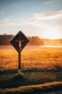 Lifeguard hut on field against sky during sunset