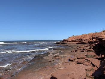 Scenic view of beach against clear blue sky