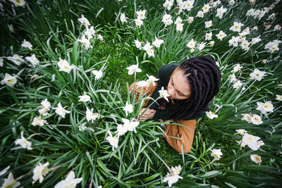 High angle view of sitting on flowering field