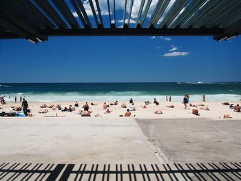 People at beach against sky