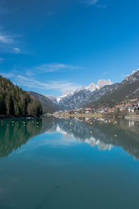 Scenic view of lake and mountains against blue sky