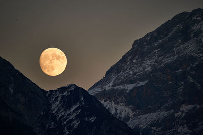 Low angle view of majestic mountains against clear sky at night