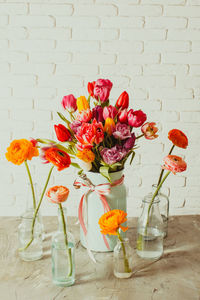 Flower vase on table against wall