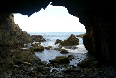 Scenic view of sea seen through cave