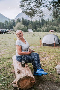 People sitting at tent against mountain