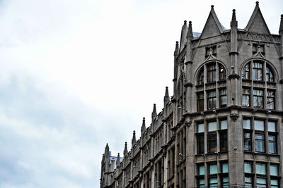 Low angle view of building against cloudy sky