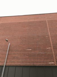 Low angle view of metal grate against sky