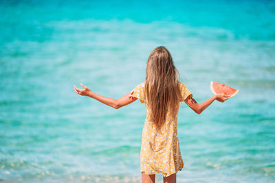 Rear view of woman standing against sea