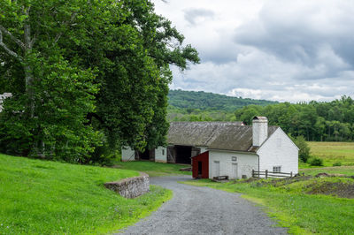 House amidst trees and houses against sky