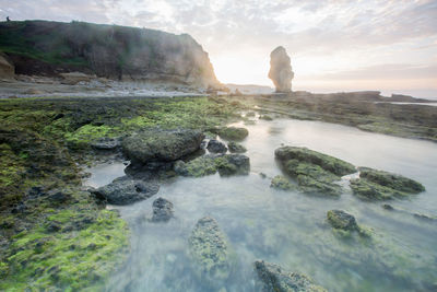 Scenic view of rocks in sea against sky