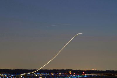 Scenic view of vapor trails against sky at night