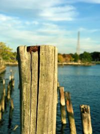 Close-up of wooden post in lake against sky