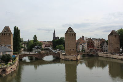 Bridge over river in city against sky