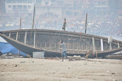 People standing on beach by city