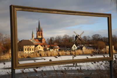 Traditional windmill and tower seen through frame during winter