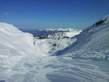 Scenic view of snow covered mountains against clear sky