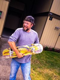 Young man holding food while standing outdoors