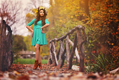 Woman standing by tree during autumn