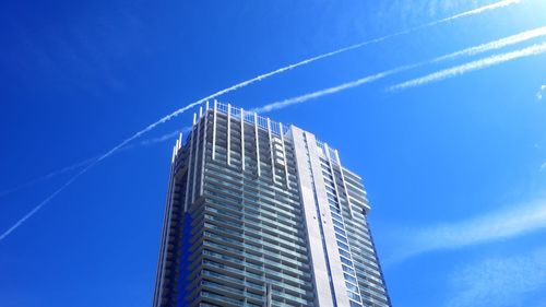 Low angle view of modern building against blue sky