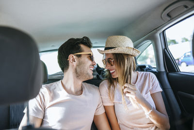 Couple laughing in the back seat of a car