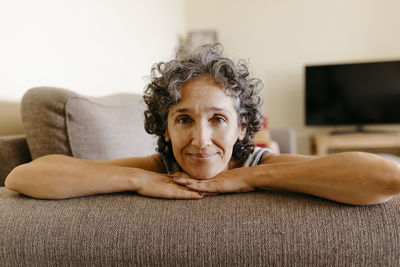 Mature woman resting on sofa at home