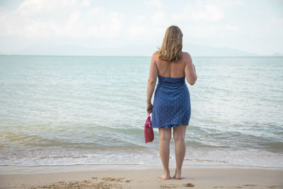 Full length rear view of man standing on beach