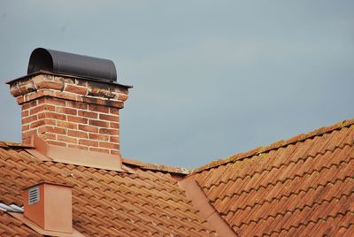 Low angle view of building roof against sky