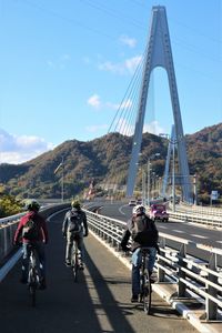 People riding bicycle on cable stayed bridge