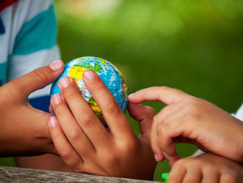 Midsection of boy holding globe on table