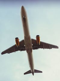 Low angle view of airplane flying against sky