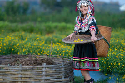 Full length of woman standing in basket on field