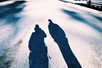 Shadow of man on snow covered road