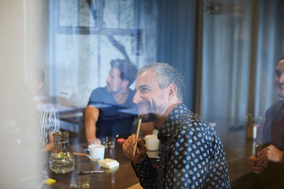 Creative business people seen through glass during meeting in office