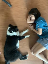 Full length of woman and cat on hardwood floor