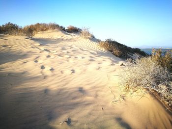 View of sand dunes against clear sky