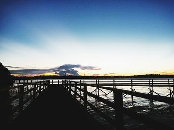 Bridge over river against sky during sunset