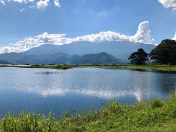 Scenic view of lake by mountains against sky