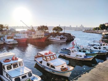 Boats moored on river in city against sky