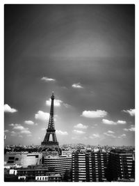 Communications tower in city against sky