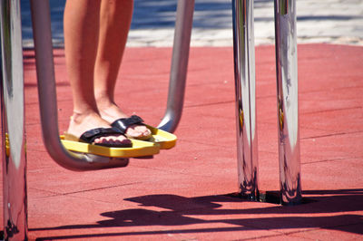 Low section of woman standing on railing